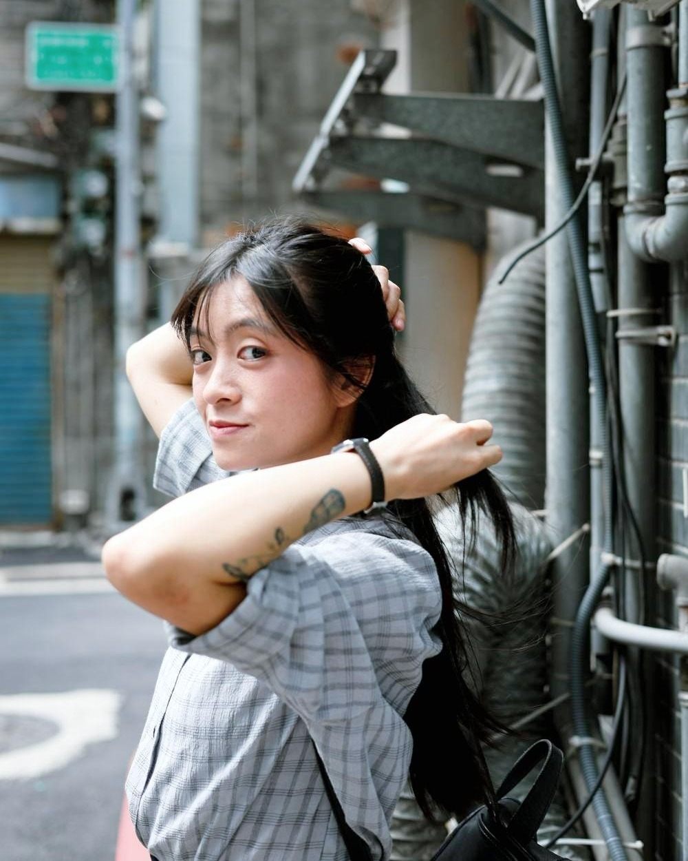 台北巷弄裡，綁著頭髮回頭微笑的女生